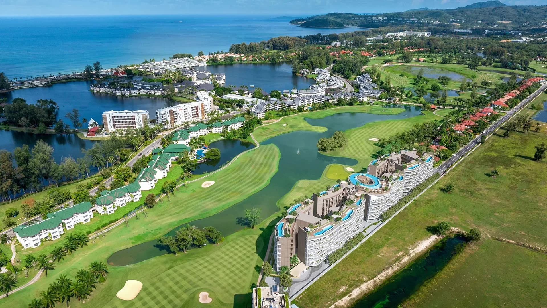 Laguna Golf, die Lagunen und die Bucht von Bang Tao aus der Luft; die Gebäude stehen am rechten Rand an der Straße